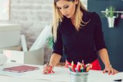 Junge Frau arbeitet an einem Stehpult Junge Frau arbeitet an einem Stehpult